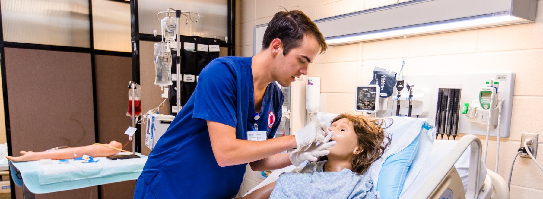 Students standing at table looking at printed information in School of Nursing Skills Lab.